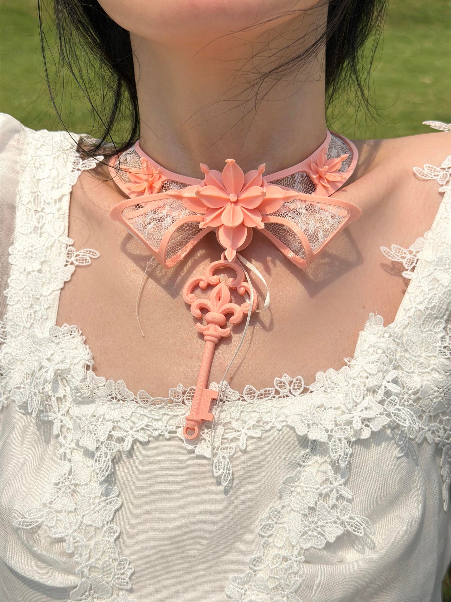 Pink 3D printed key choker with lace bow collar — close-up