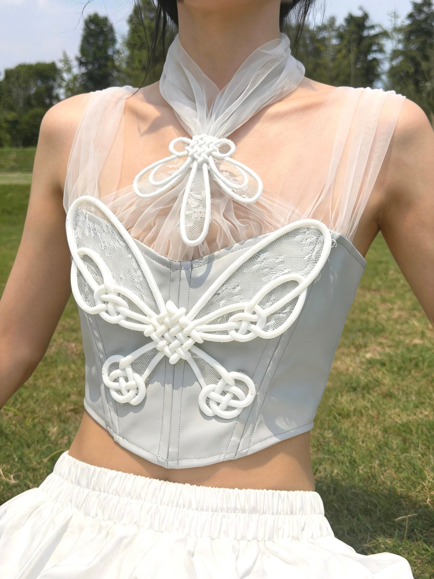 Silver 3D printed butterfly knot corset styled with white skirt — full front view